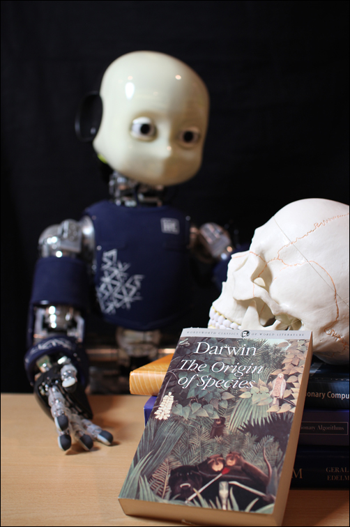 Picture with an iCub robot and Darwin's book Origin of Species